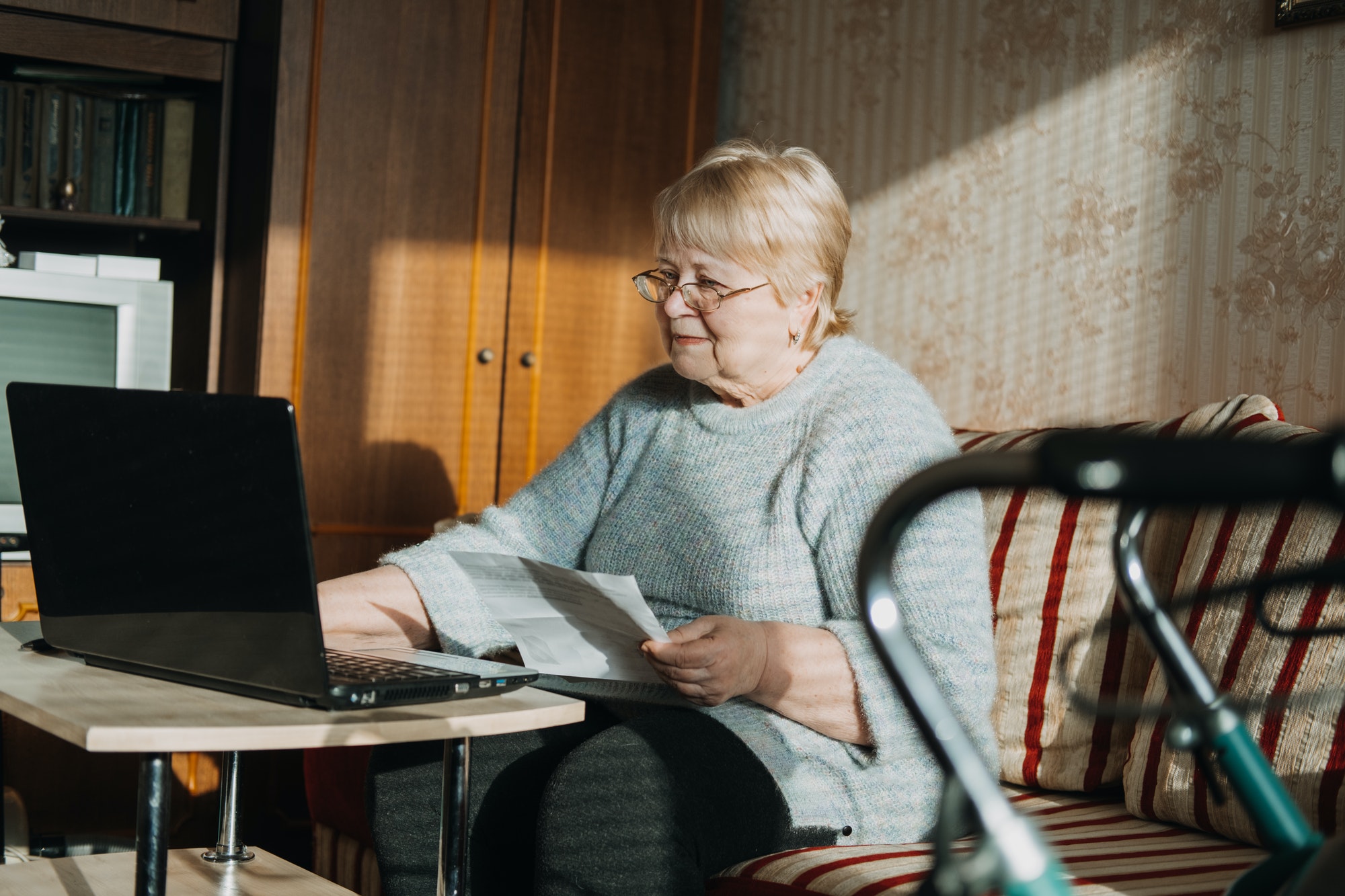 Life Insurance, Disability medical insurance policy for Seniors. Mature woman in glasses with Laptop