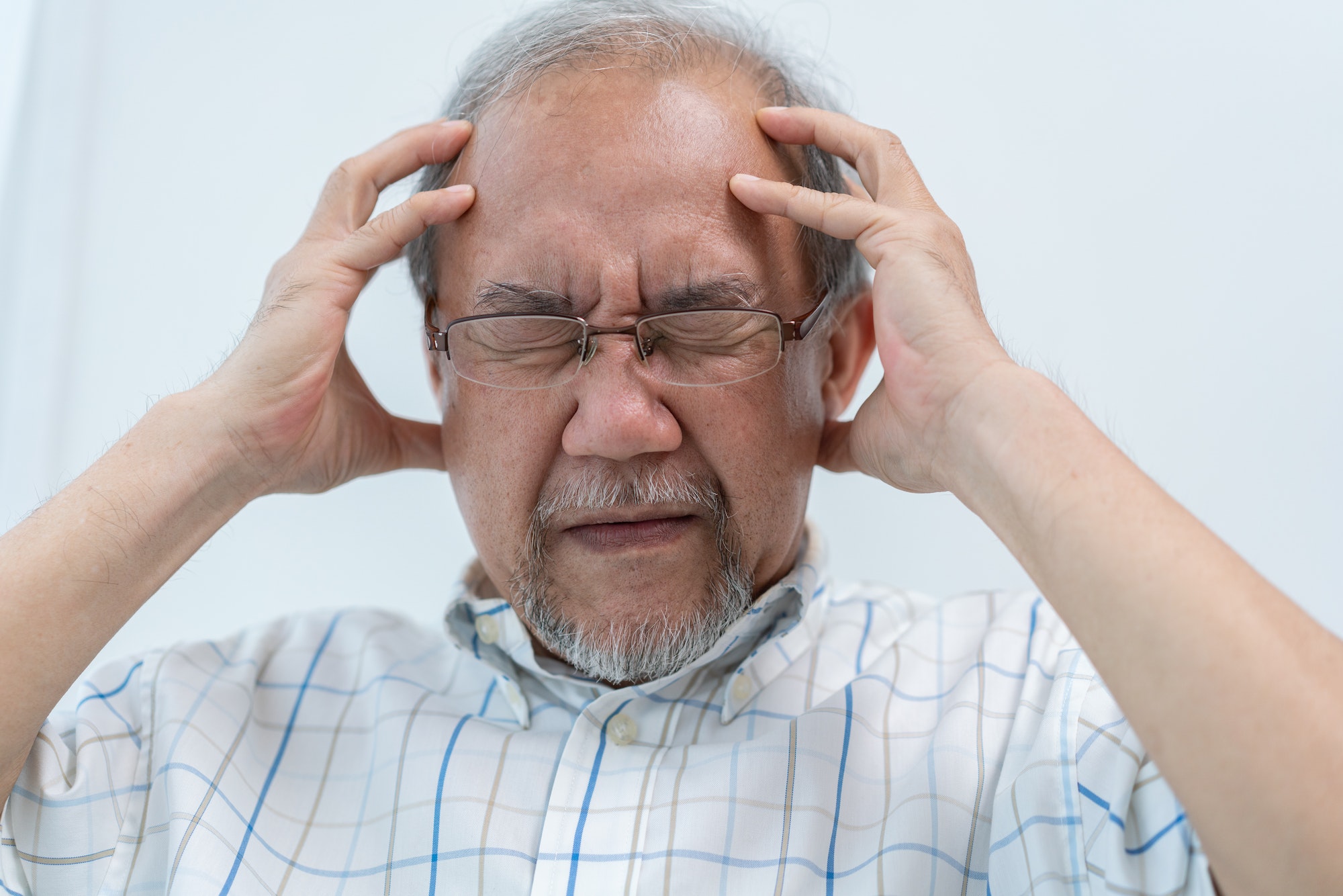 Asian senior man having headache. Stressed and depressed from health problem