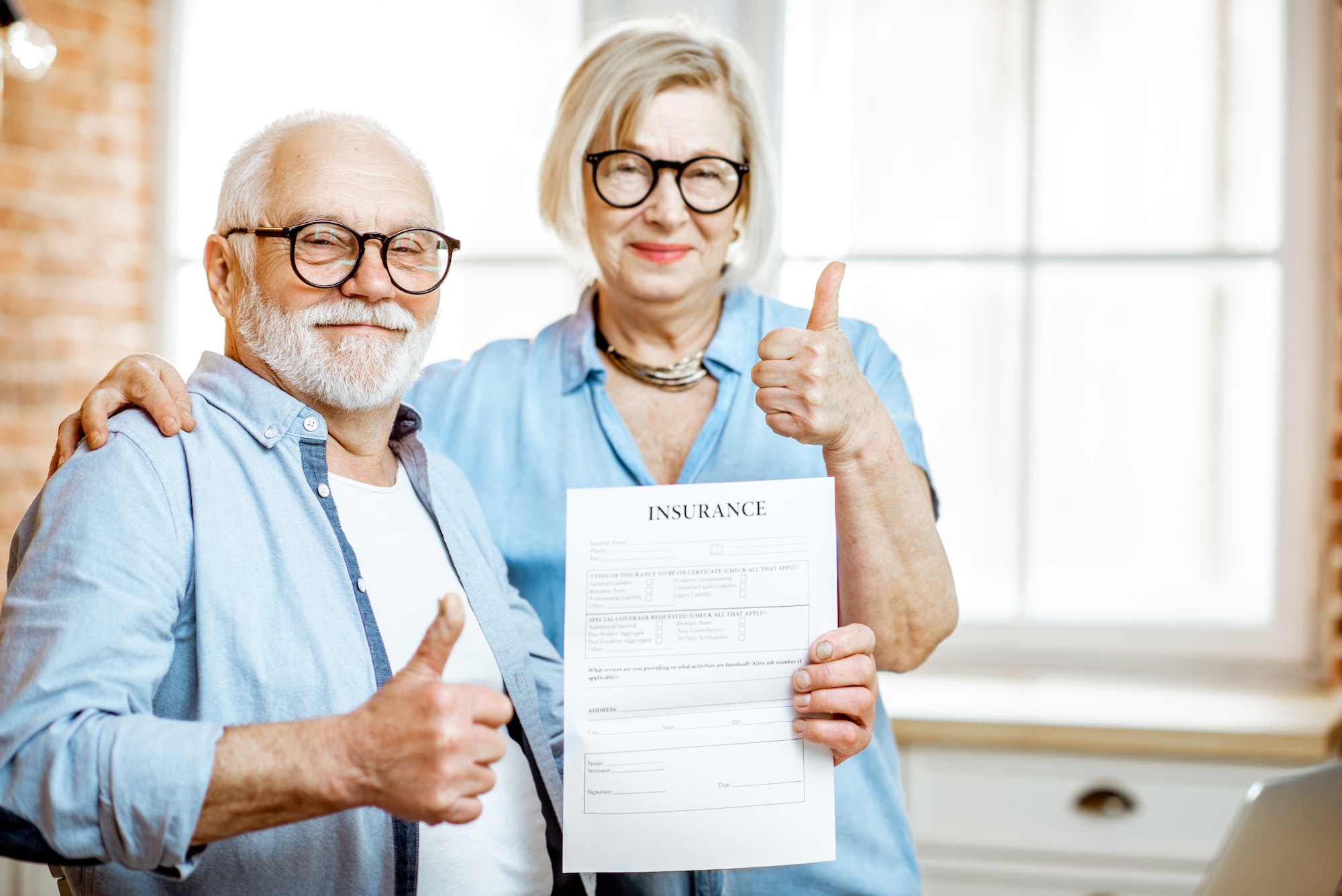 Happy senior couple with insurance document