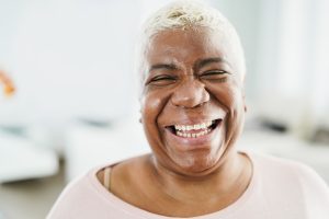 Portrait of happy senior african woman looking at camera at home - Focus on face