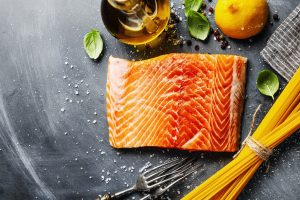 Salmon with ingredients on table