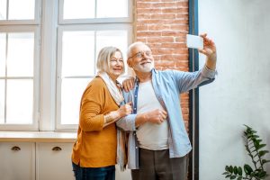 Senior couple with smart phone at home
