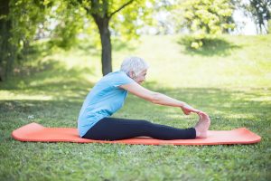 Senior lady enhancing body flexibility by stretching